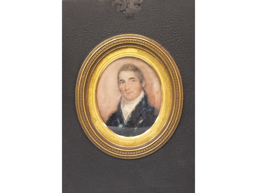 A 19th century oval portrait miniature of a gentleman wearing a blue coat and white stock within
