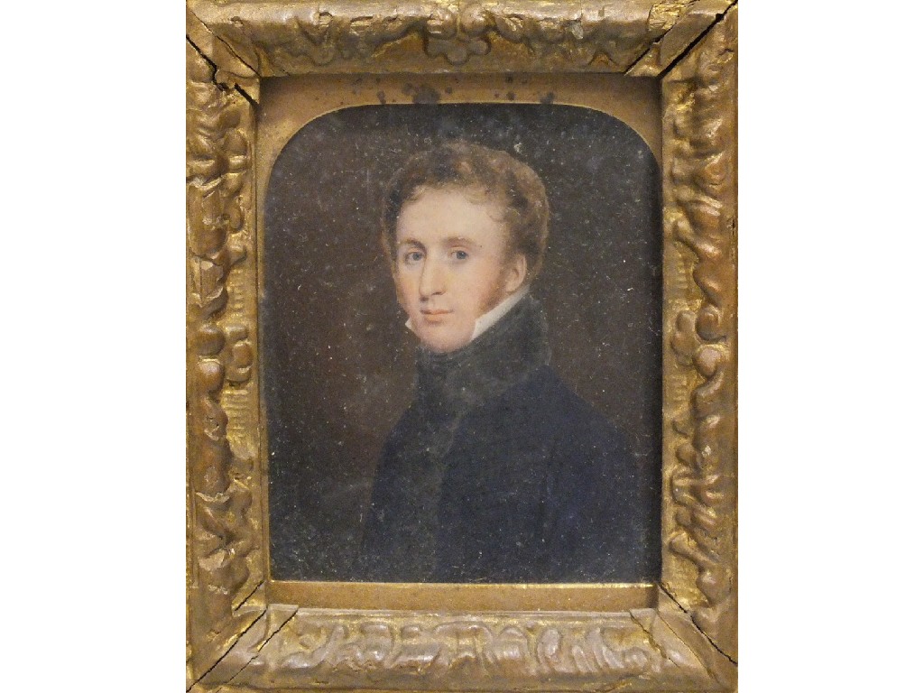 A Victorian portrait miniature on ivory of a young man wearing a blue tunic and white collar, within
