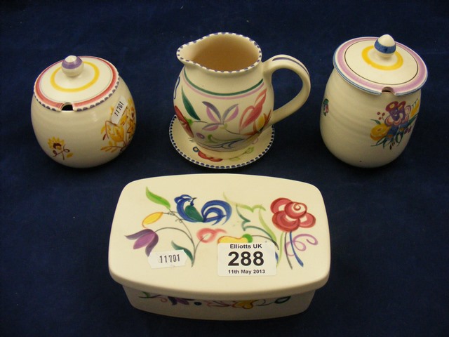 A Poole Pottery butter dish together with two lidded pots, jug and pin dish