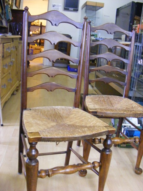 Six ladder back chairs with rush seats and pad feet