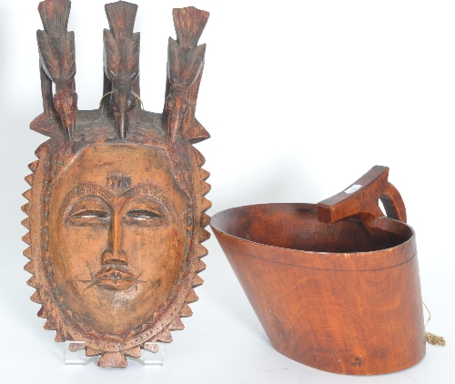 An African tribal mask, the headdress in the form of three birds above the open slit eyes,