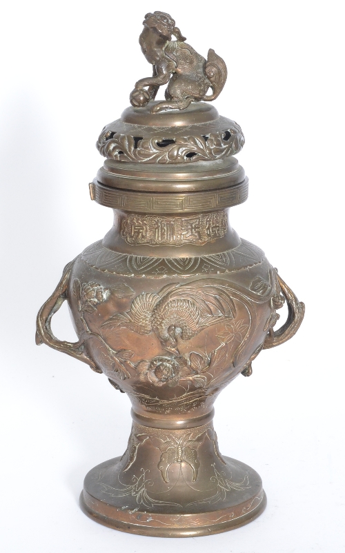 A 20th Century Chinese bronze vase and cover, raised with peacock and floral design below a seated