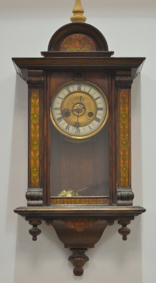 An early 20th Century walnut wall clock with painted border detail to the case, the enamelled
