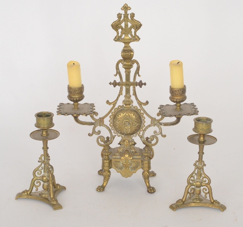 A late 19th Century Aesthetic brass candlestick garniture, comprising a twin branch candelabra and a
