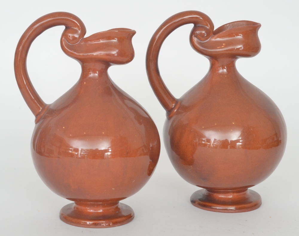 A pair of early 20th Century jugs in the style of Dr. Christopher Dresser, each of swollen belly