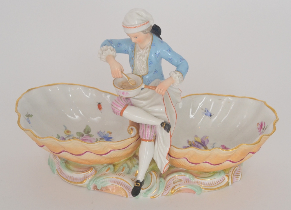 A 19th Century Meissen table salt modelled with a central figure of the cook holding a saucepan in