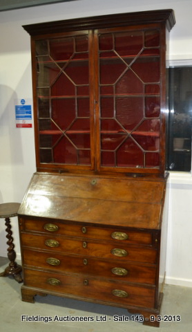 A George III mahogany bureau bookcase, enclosed by a pair of astragal glazed doors below a dentil