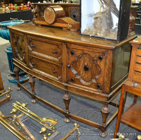 A 1920`s Jacobean style oak breakfront sideboard, fitted with two deep central drawers, flanked by a