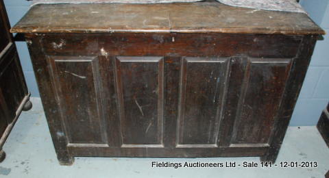 A large 18th Century oak coffer with a plain lid above a quadruple panel front and stile feet, later