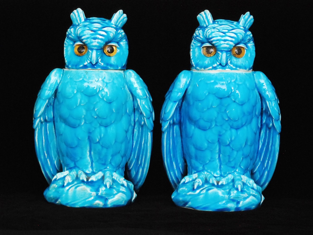 A pair of early 20th Century jars and covers modelled as owls with inset glass eyes decorated in