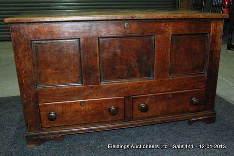 A George III oak mule chest, the hinged top opening to reveal a candlebox over a triple panelled