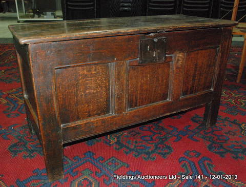 An 18th Century oak coffer of small proportions, the replacement lid  above a triple fielded front