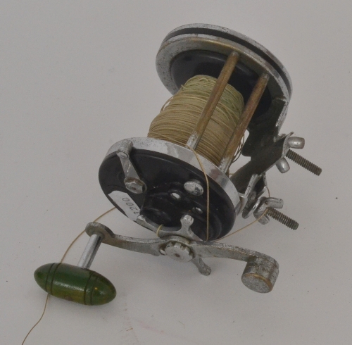 A multiplier fishing reel, Penn squidder, embossed ebonite sides and green stained handle, width