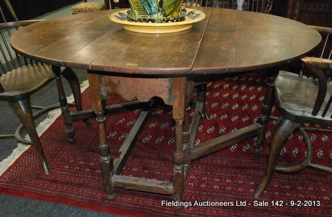 An 18th Century oak gate-leg table with later repairs and alterations, the hinged oval top above a