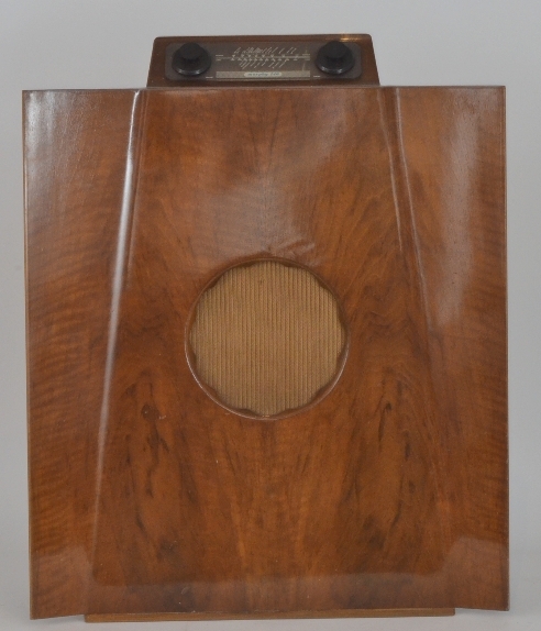 A mid 20th Century walnut cased floor standing radio of concave form by Gordon Russell for Murphy