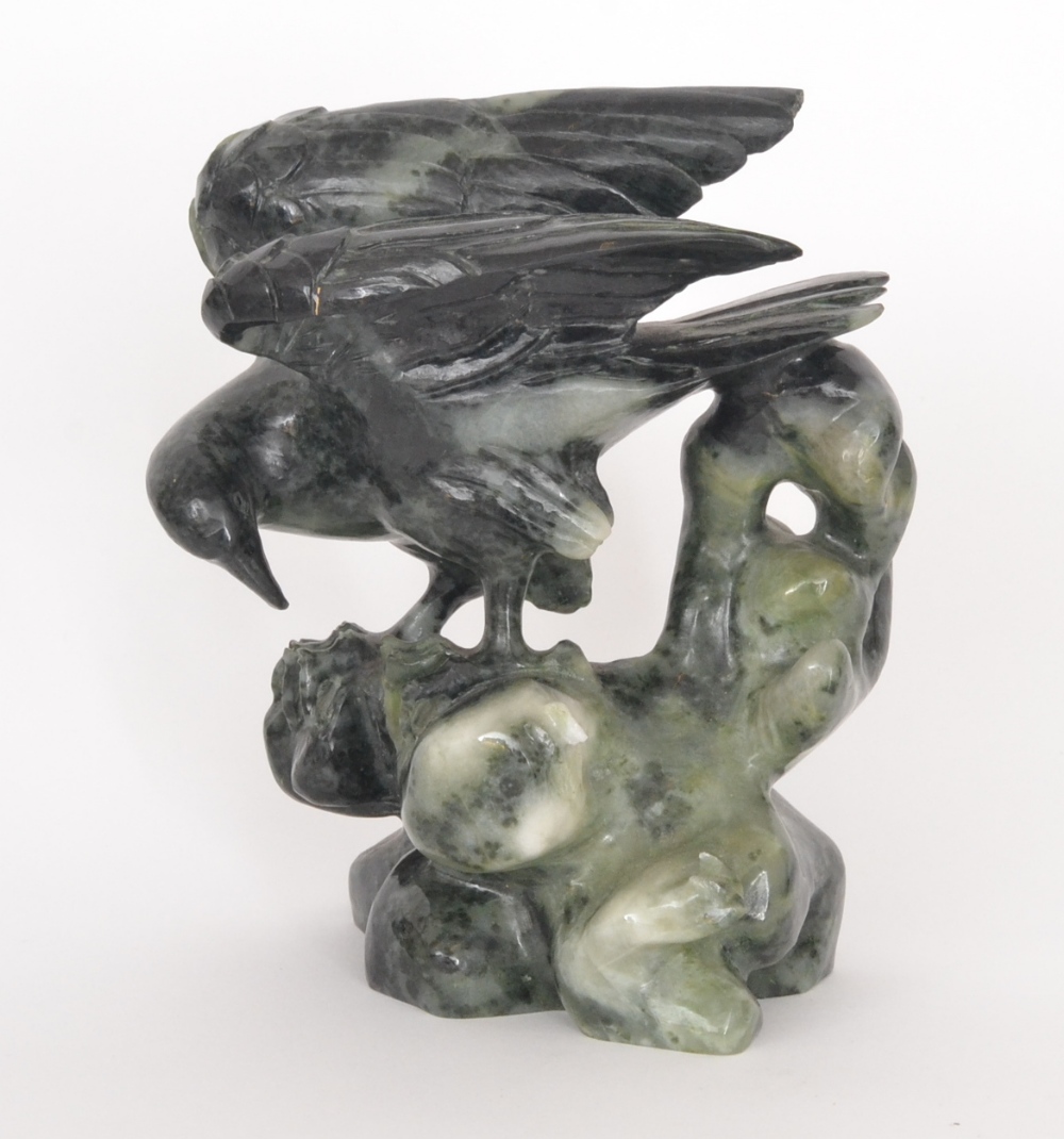 An Oriental carved hardstone study of an eagle upon a rocky outcrop, S/D, 16cm high.
