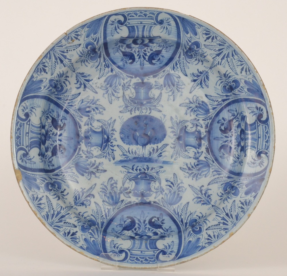 An 18th Century Delft tin glazed plate decorated to the central well with a peacock displaying his