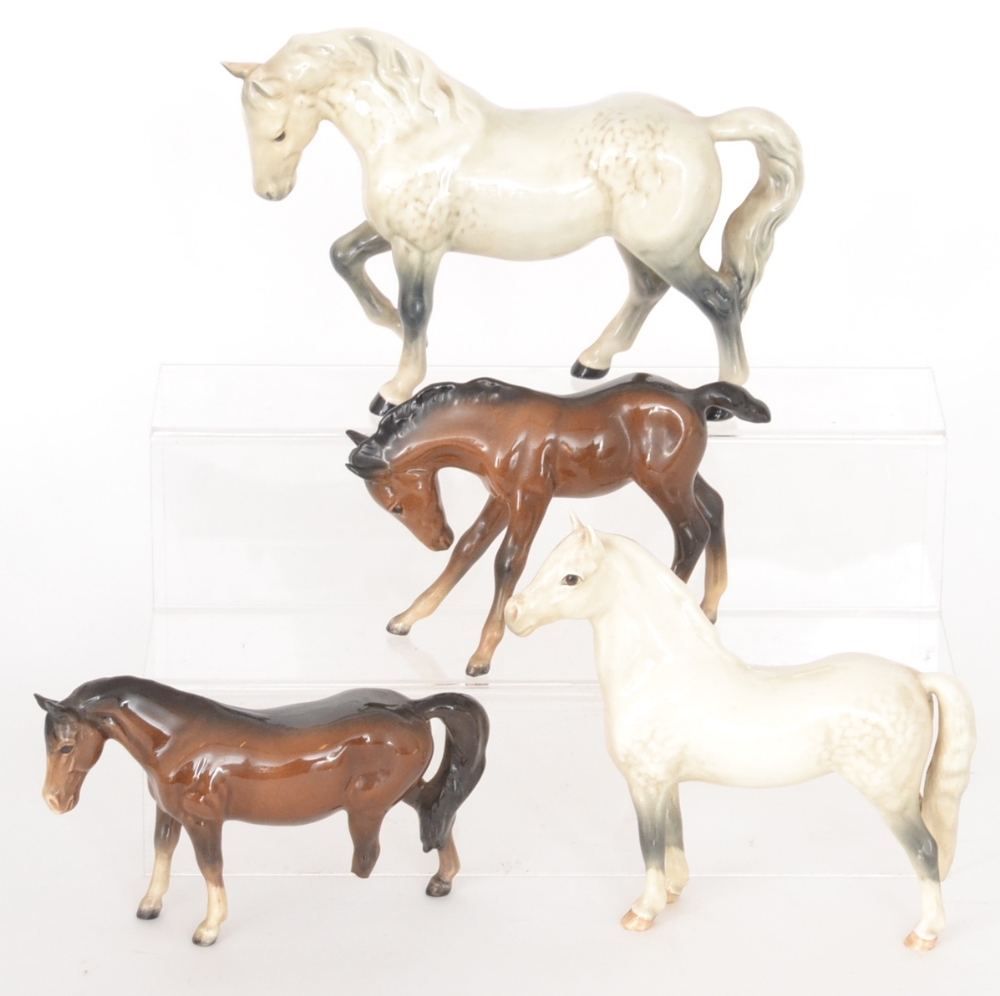 Four Beswick horses comprising two brown foals and two white mares (two S/D)