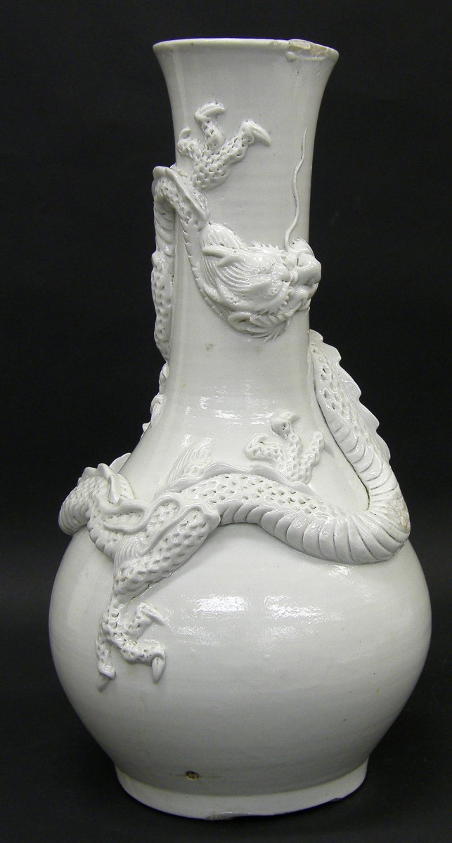 Chinese blanc de chine bottle neck porcelain vase, decorated in high relief with a coiled dragon,