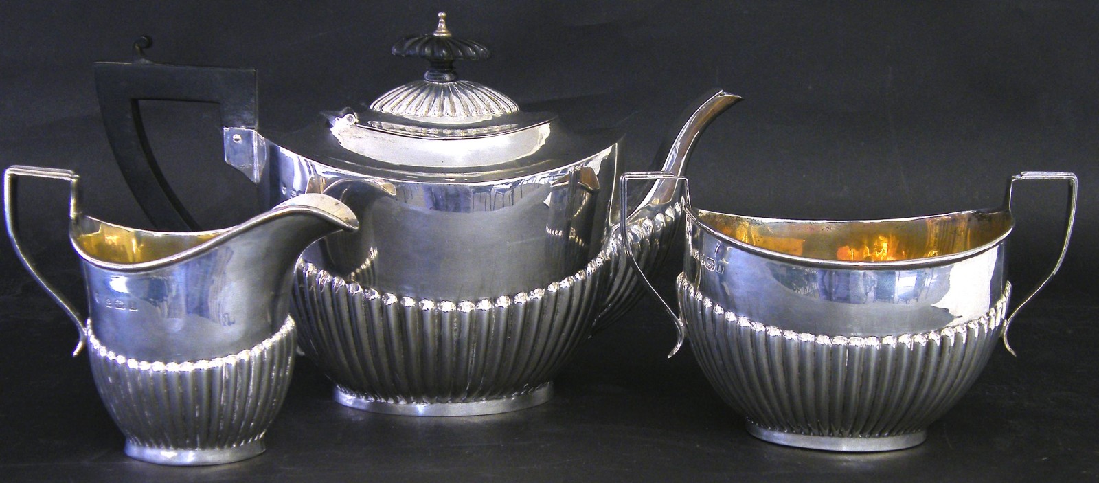 George V silver three piece tea service comprising teapot, twin handled sucrier and milk jug, with