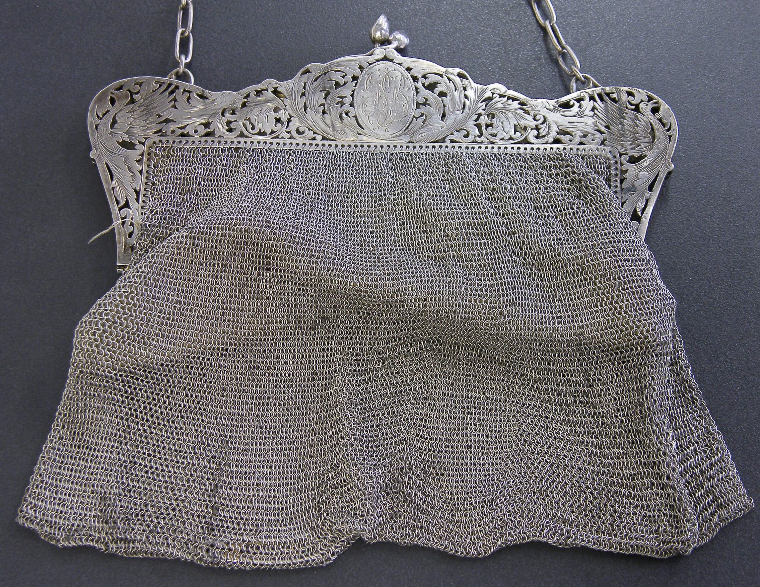 Continental white metal mesh link evening bag, with a decorative pierced engraved clasp with birds