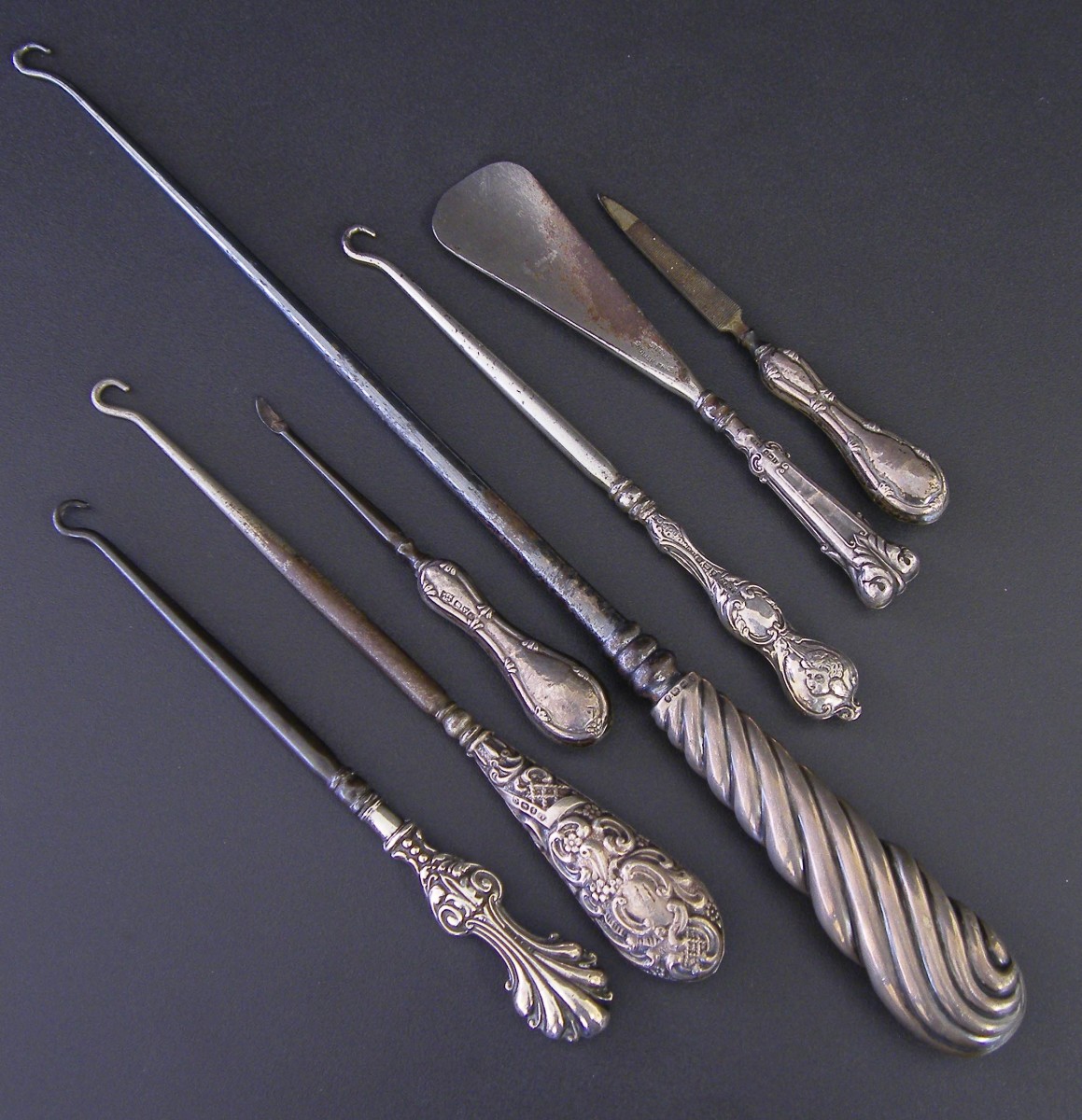 Collection of four antique silver handled boot hooks; together with silver handled shoe horn and two