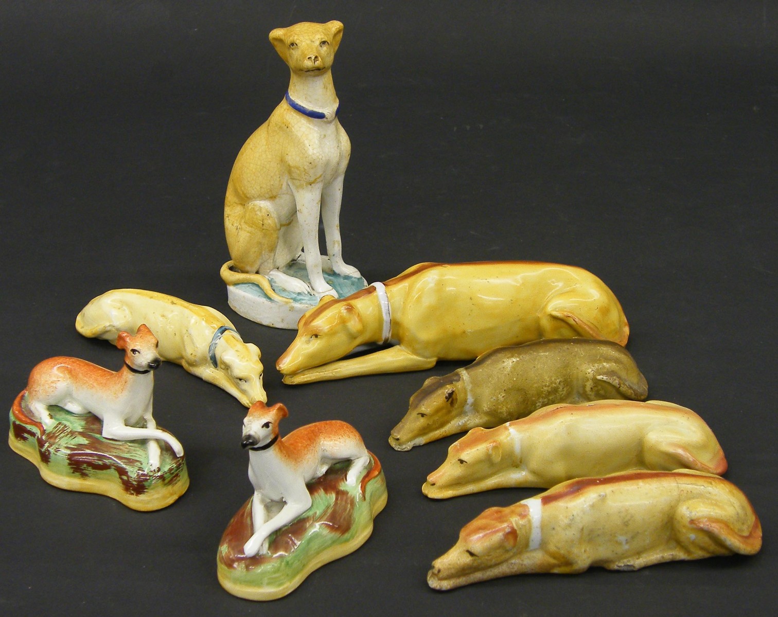 Five various Staffordshire porcelain studies of greyhounds, the largest 7" long; together with three