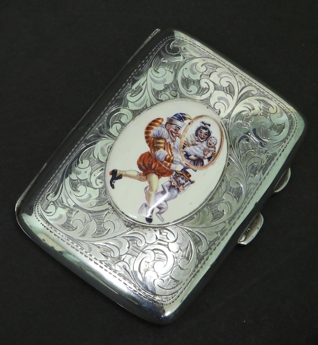 1920s silver hip shaped cigarette case engraved with scrolling acanthus and fitted with an oval