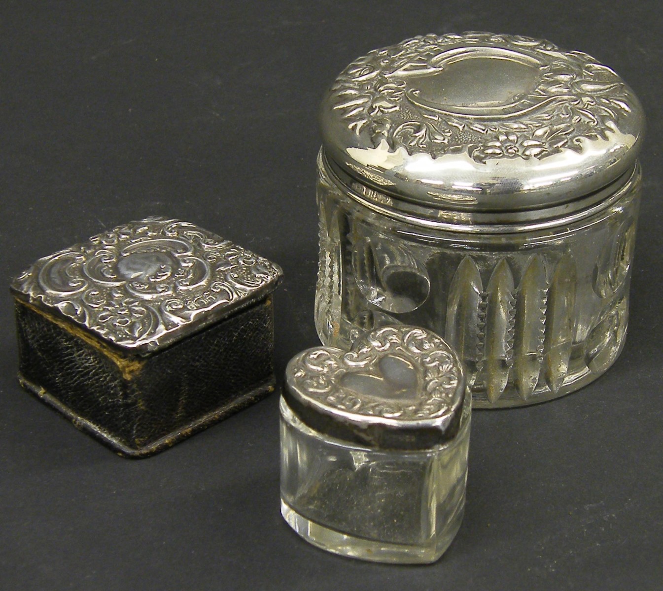 Edwardian silver lidded scent jar embossed with flowers and cartouches, maker`s marks indistinct,