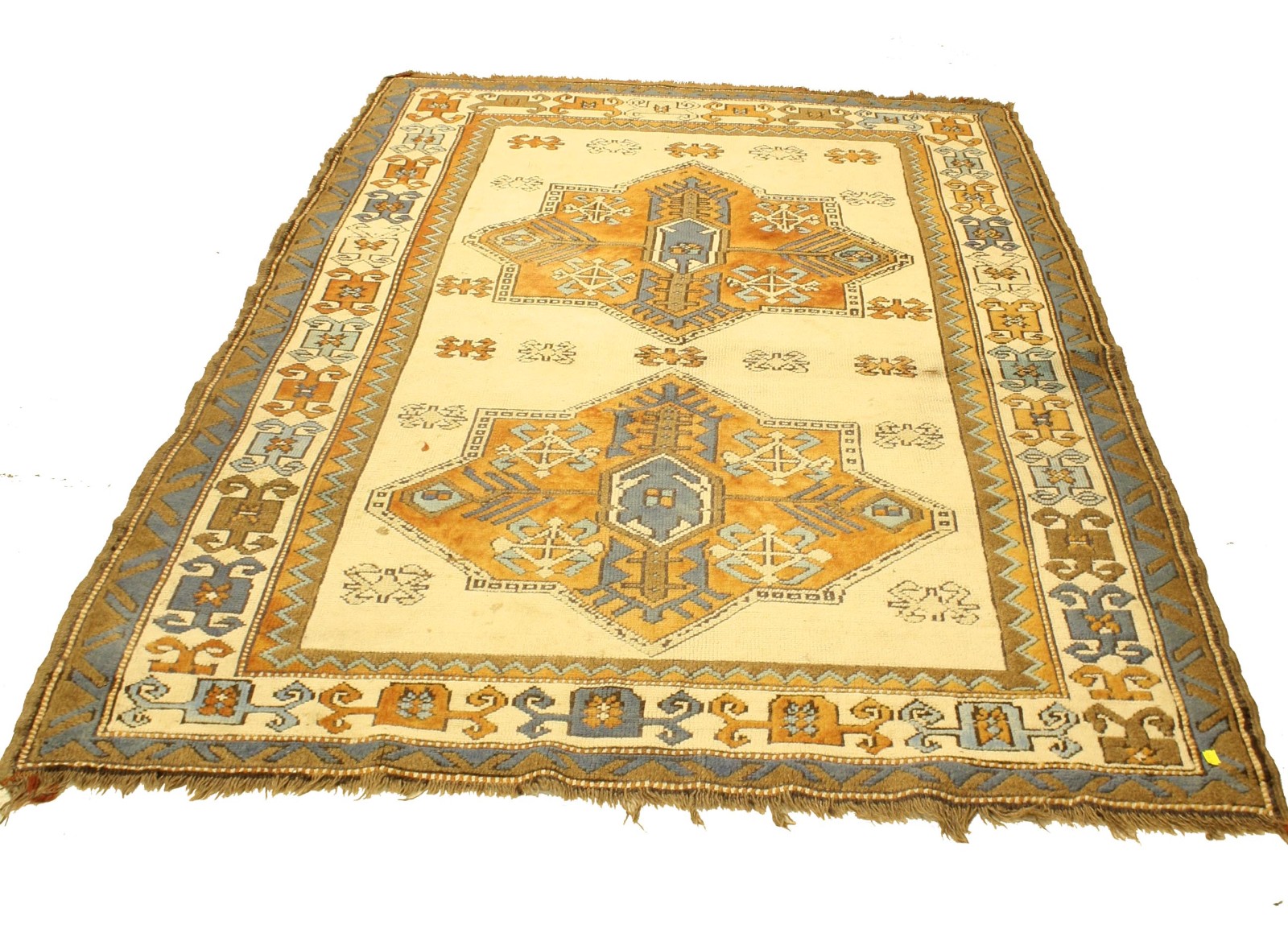 Caucasian design floor rug, decorated with two orange star shaped medallions upon a cream ground,