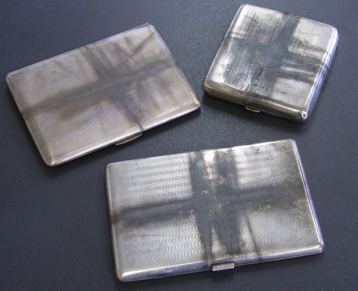 Three silver engine turned cigarette cases, 15.2oz (3)