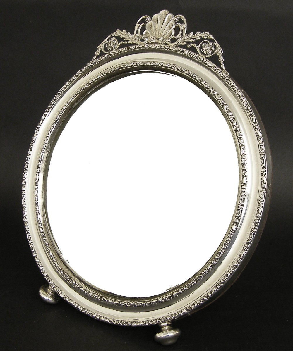 Attractive silver circular easel mirror, with a cast scroll surround and foliate shell cresting,