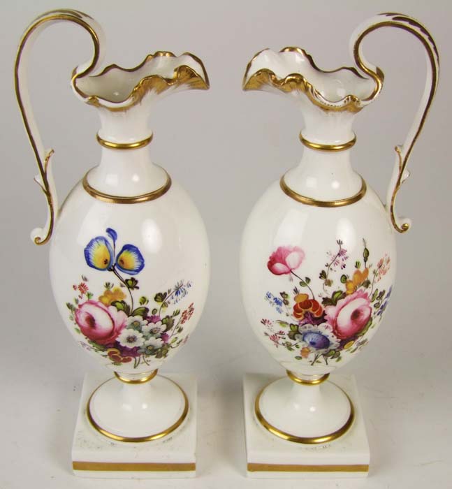 A pair of porcelain ewers, with gilt edges, and sprays of flowers, on square base, height 23cm (