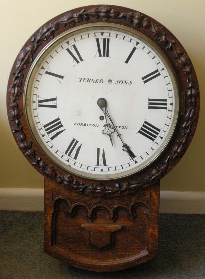 A carved oak drop dial timepiece, the white dial signed Turner & Sons, Surbiton & Sutton, fusee