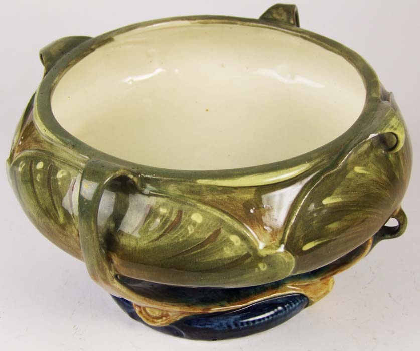 An Austrian pottery bowl, the bellied top on a turned pedestal with four supports, on domed circular