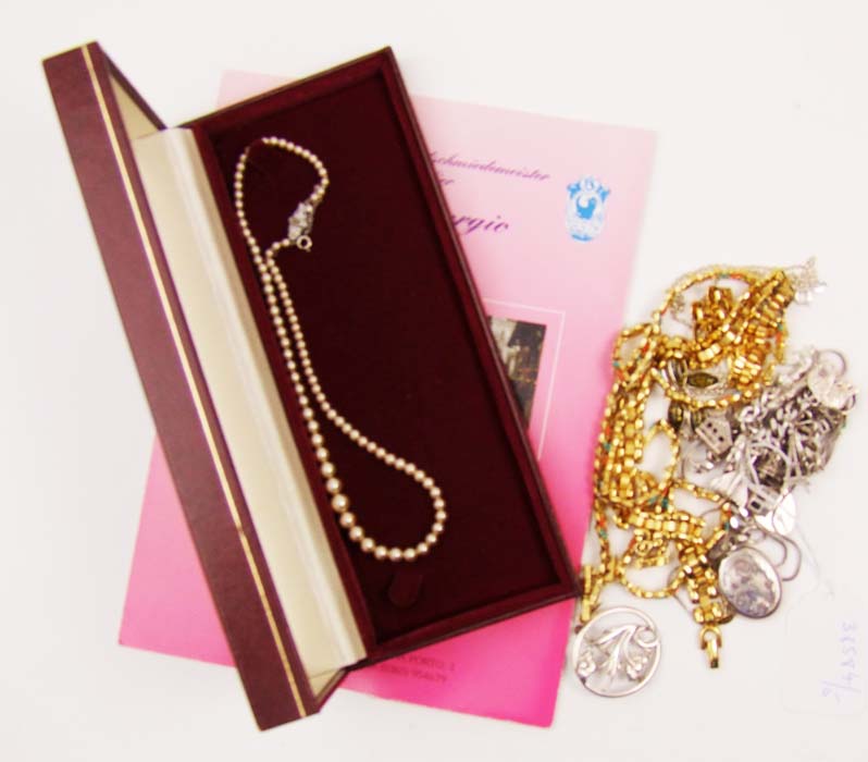 A quantity of costume jewellery, including a charm bracelet, a locket and chain, and an amber