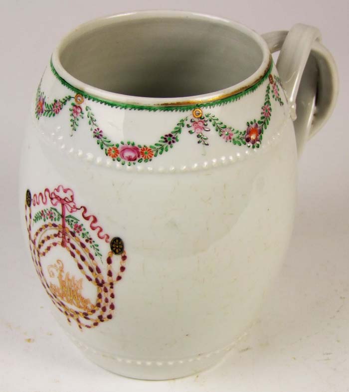 A Chinese export mug, the rim with floral swags, and bearing a gilt monogram, height 14cm (5 1/2in).