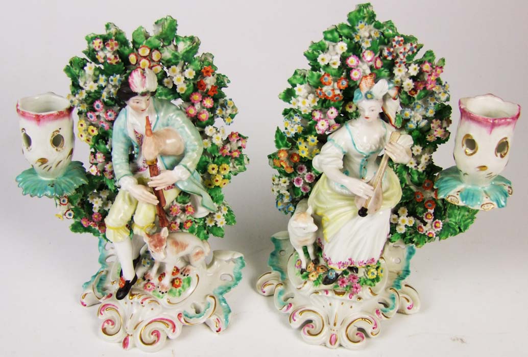 A pair of Derby candlestick figures of musicians, in front of flowering bocage, height 19.5cm (7 3/