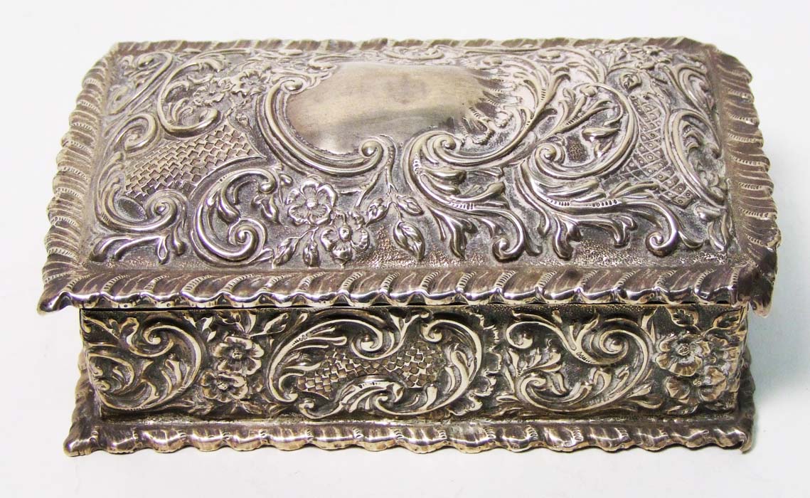 A Victorian rectangular box, richly embossed with foliate scrolls, domed hinged cover, gadrooned