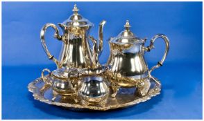 A Silver Plated Four Piece Tea And Coffee Service, with a large circular silver plated tray. Teapot