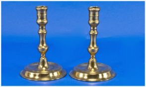 Pair Of George I Brass Candlesticks, with a turned baluster stem supported by a round base with