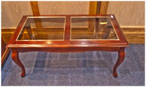 Mahogany Coloured Glass Topped Coffee Table. 38 by 19 inches.