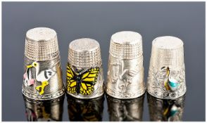 Four Unusual Silver and Silver And Enamel Thimbles. A pair decorated with storks delivering babies.