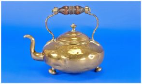 Antique Brass Scottish Tea Kettle with a wood handle on three brass round feet.