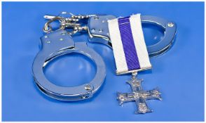 Smith Fargo Texas Handcuffs together with a copy of British military cross.