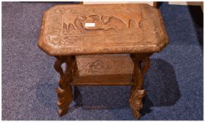 A Small Carved Burmese Side Table. The top carved with elephant decoration, the legs in the shape