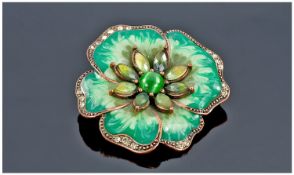 An Enamel on Copper Brooch. Designed as a two tone green flower head. The centre and outer edge set