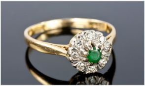 18ct Gold Set Diamond And Emerald Cluster Ring. The central emerald surrounded by 8 small diamonds.