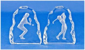 A Pair Of Sporting Glass Paperweights, golf and tennis players. Each 7 inches high.