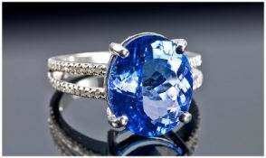 A Single Stone Oval Tanzanite Ring, set in 14ct gold. With diamond set shoulders. The fine